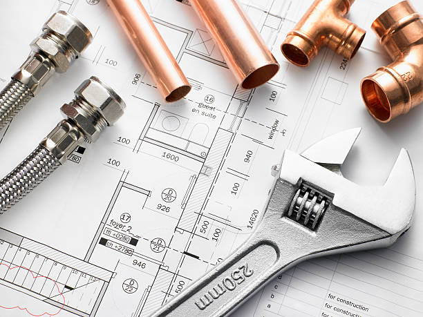 Plumbing tools and copper piping arranged over a home floor plan